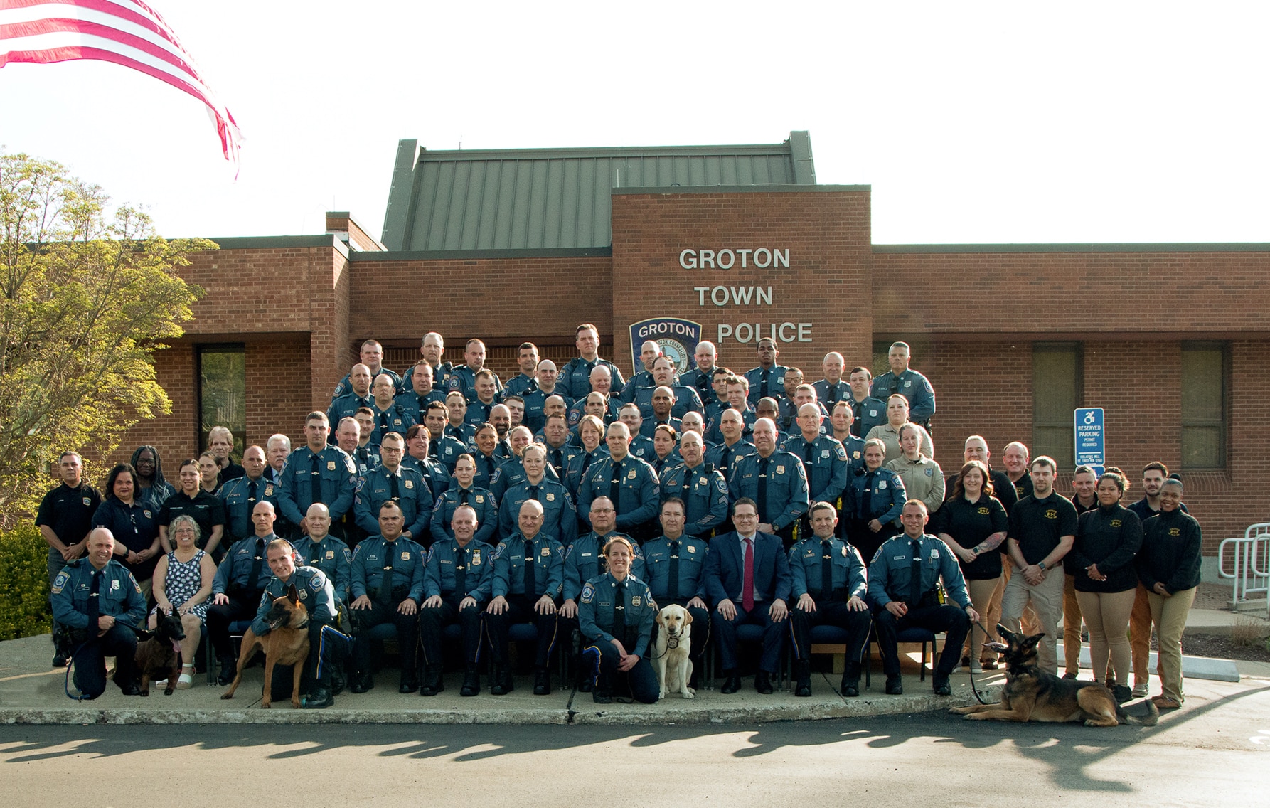 Four Groton, Connecticut Police Officers pose for a photo with the department comfort dog.